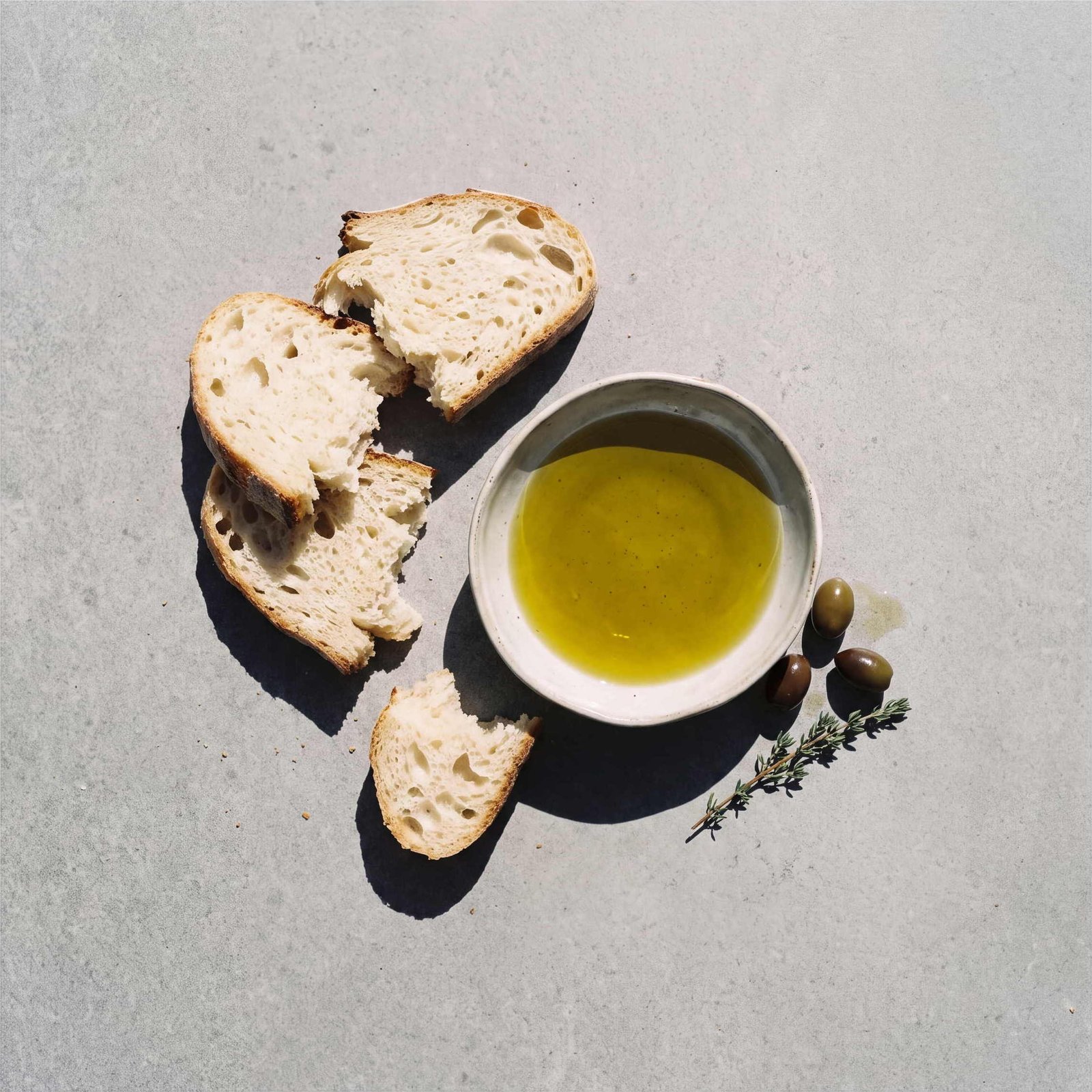 Bread and a dish of olive oil on stone